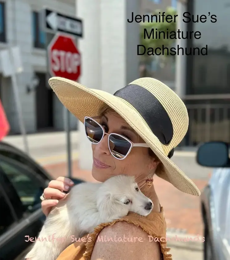 A woman holding a small dog in her arms.